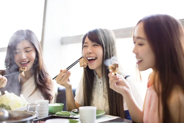 Glada unga kvinnor grupp äta köttgryta — Stockfoto