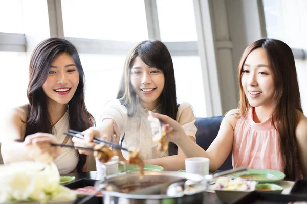 Feliz jovem Mulheres grupo Comer panela quente — Fotografia de Stock