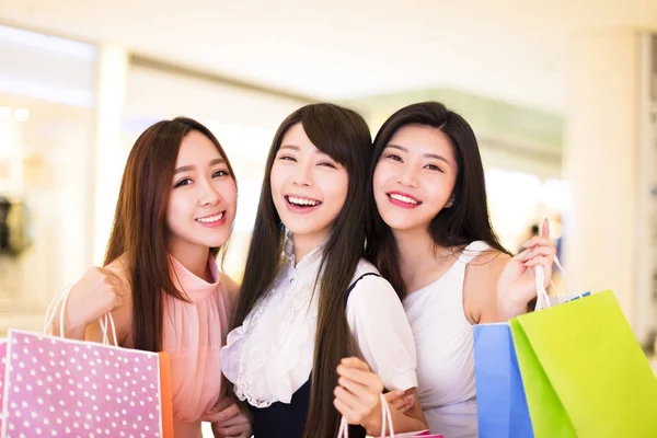 Grupo mulher feliz segurando sacos de compras no shopping — Fotografia de Stock