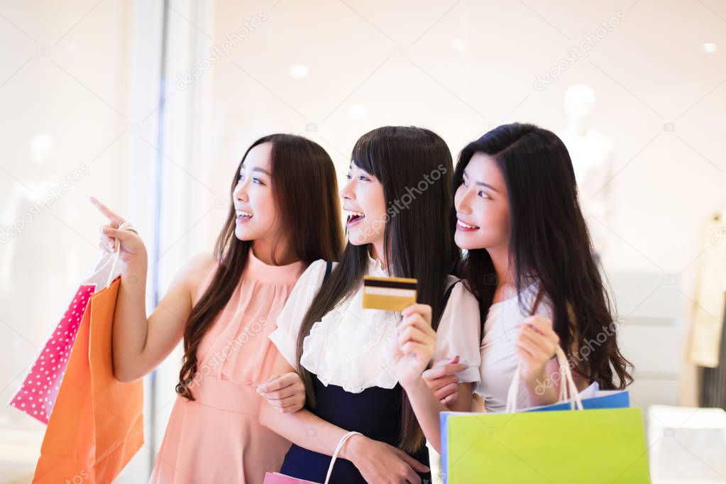 happy woman group holding shopping bags and  credit card at  mall