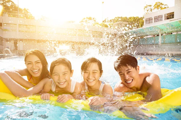 Familia feliz jugando en la piscina — Foto de Stock