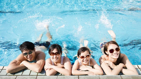 Famille heureuse jouant dans la piscine — Photo