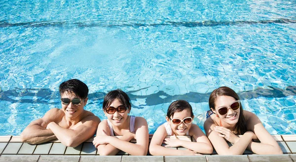 Famille heureuse jouant dans la piscine — Photo