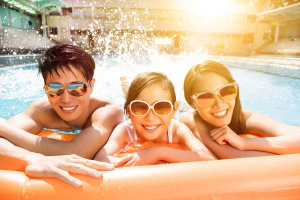 Familia feliz jugando en la piscina — Foto de Stock