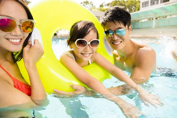 Счастливая семья играет в бассейне — стоковое фото