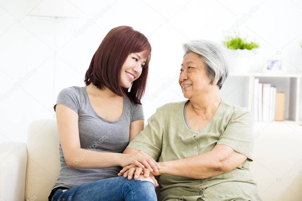 Grandmother and granddaughter. Young woman carefully takes care of old woman