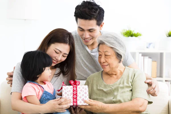 Menina feliz dando presente a seu grandmothe — Fotografia de Stock