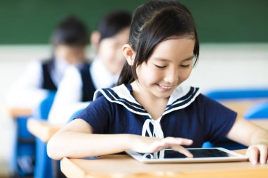 gülümseyen küçük kız sınıfta Tablet PC'yi kullanma
