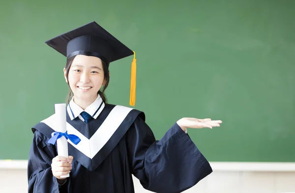 Lächelndes Abschlussmädchen mit Geste im Klassenzimmer — Stockfoto