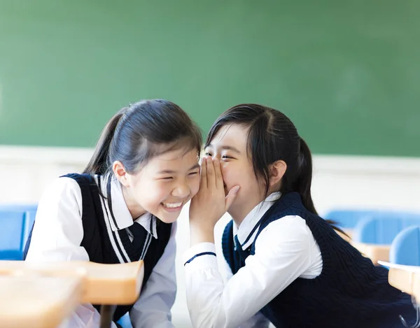 Due ragazze adolescenti spettegolano in classe — Foto Stock