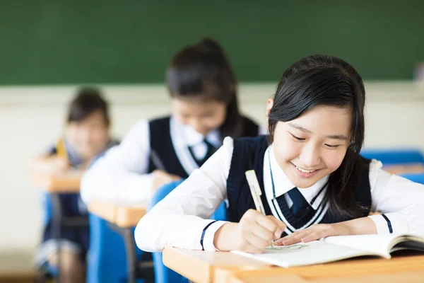 Ler student tjej i klassrummet och hennes vänner i bakgrunden — Stockfoto