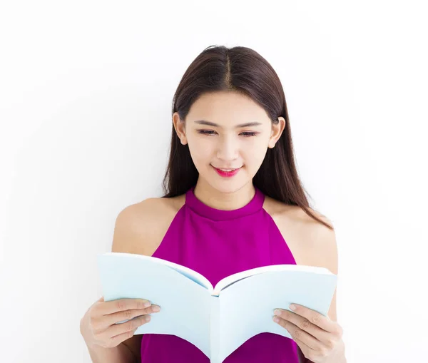 Sorrindo jovem leitura livro contra a parede branca — Fotografia de Stock