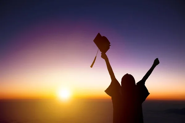 Silhouette einer Studentin, die ihren Abschluss feiert und dem Sonnenlicht zusieht — Stockfoto