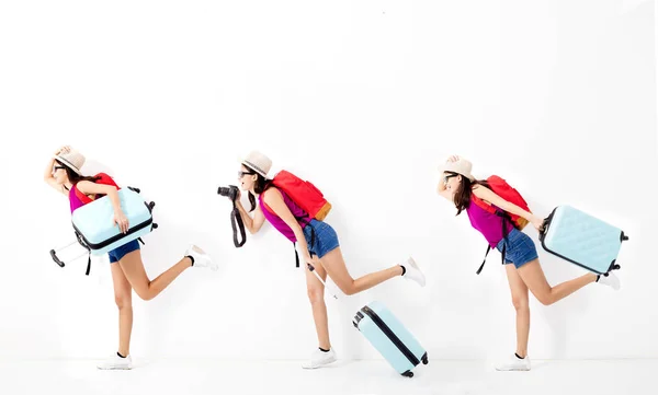 Счастливая молодая женщина держит чемодан и бежит в путешествие — стоковое фото