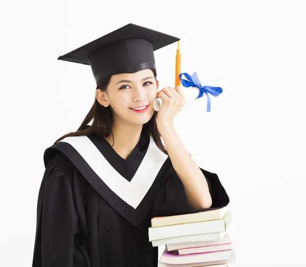Kitap yığını ile mezuniyet şapkalı mutlu öğrenci — Stok fotoğraf