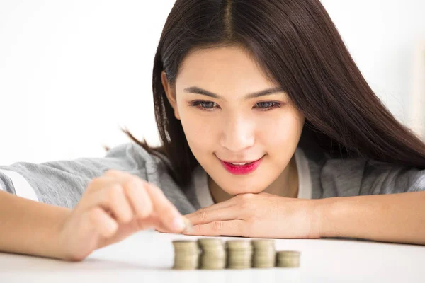 Молодая женщина положила монеты в стопку, экономя деньги концепции — стоковое фото