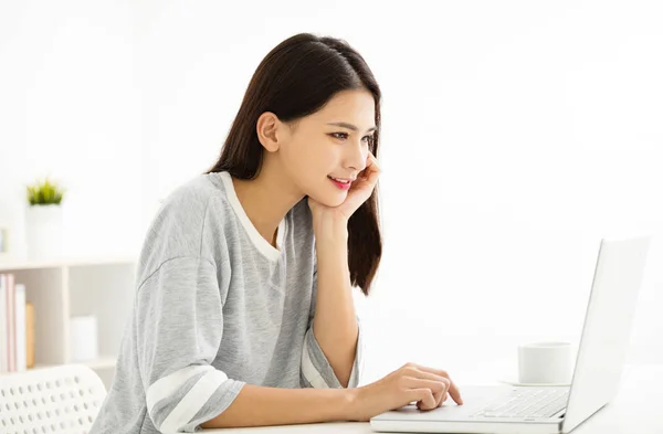 Bela jovem mulher sorrindo e olhando para laptop — Fotografia de Stock
