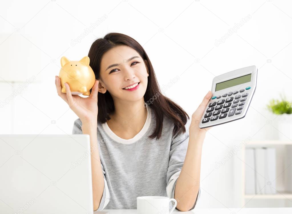 Young Woman showing Calculator  and Piggybank