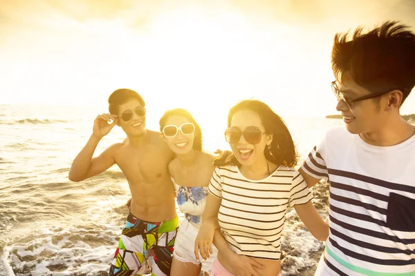 Gelukkig jonge groep wandelen op het strand genieten van de zomervakantie — Stockfoto