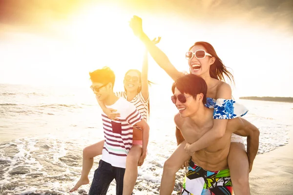 Feliz jovem grupo correndo na praia — Fotografia de Stock