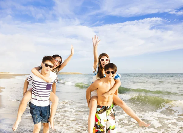 Fröhliche junge Gruppe läuft am Strand — Stockfoto