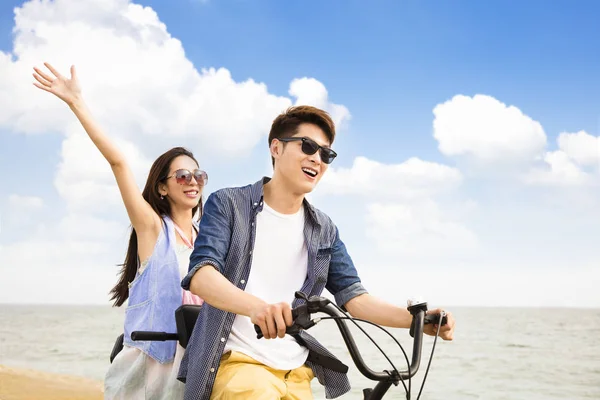 Feliz jovem casal andar de bicicleta na praia — Fotografia de Stock