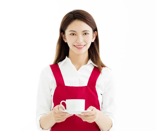 Mladá žena s úsměvem a ukazující šálek kávy — Stock fotografie