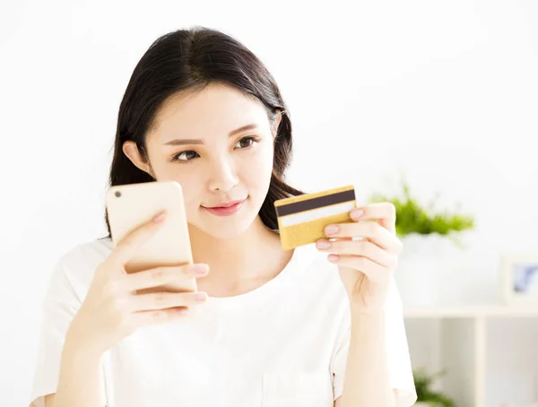 Mujer compra en línea con tarjeta de crédito y teléfono inteligente —  Fotos de Stock