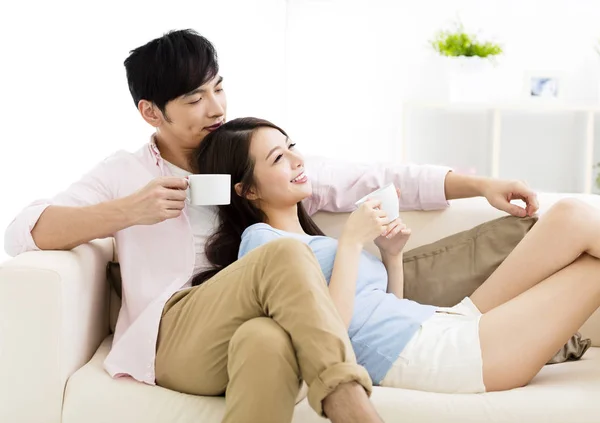 Retrato de una joven pareja sonriente sentada en un sofá —  Fotos de Stock