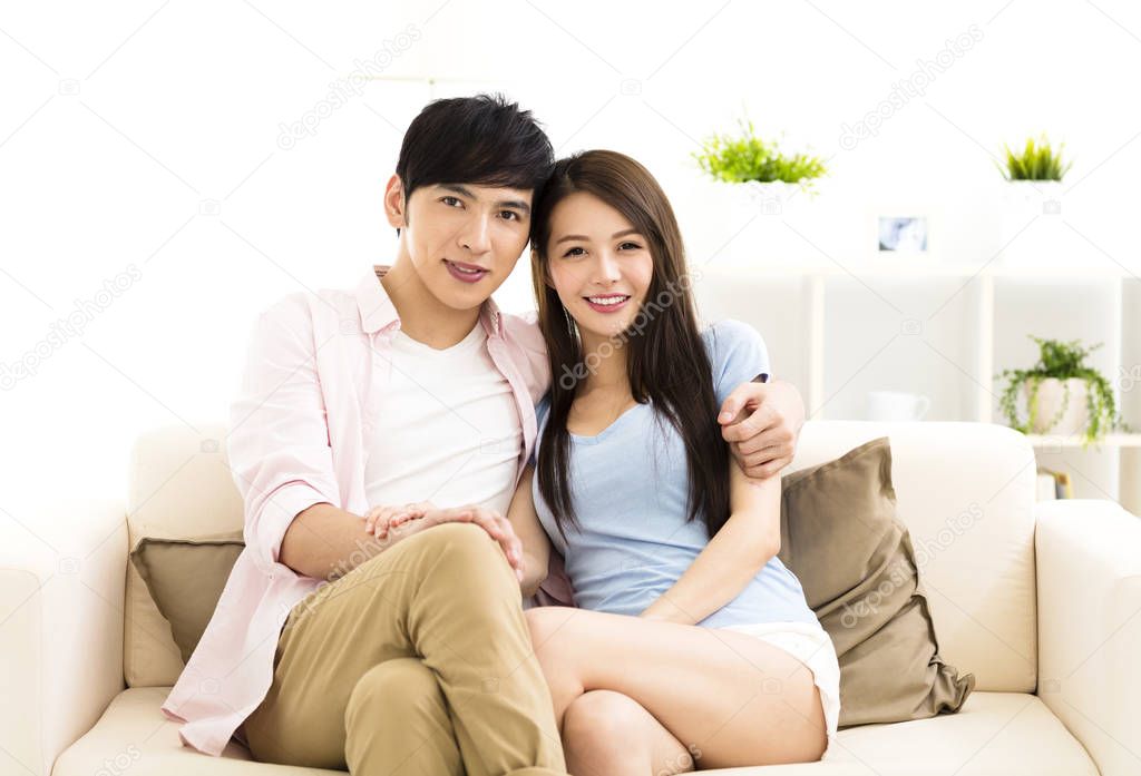 Portrait of  smiling  young couple sitting on sofa