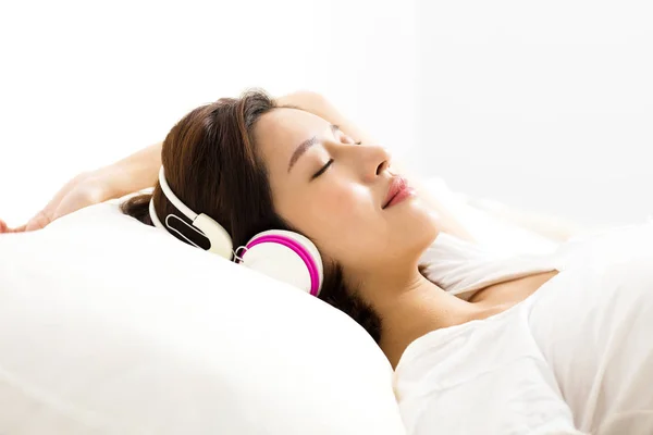 Young woman listening to music with headphones in b — Stock Photo, Image