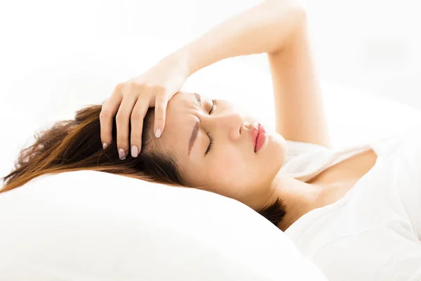Jovem Mulher com dor de cabeça na cama — Fotografia de Stock