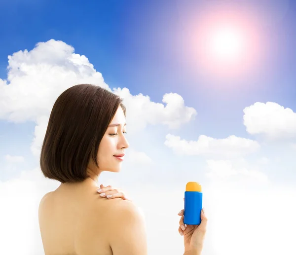 Junge Frau zeigt Sonnenschutzcreme — Stockfoto