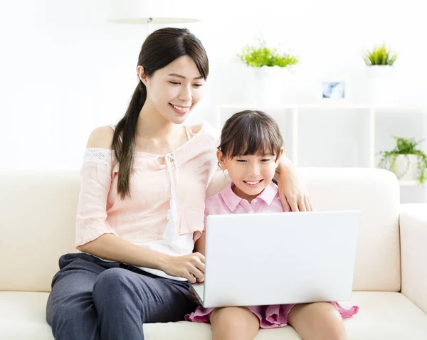 Matka z córką, patrząc na laptopa na kanapie — Zdjęcie stockowe