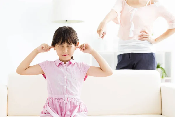 Niña molesta cubriéndose las orejas mientras su madre se enoja — Foto de Stock