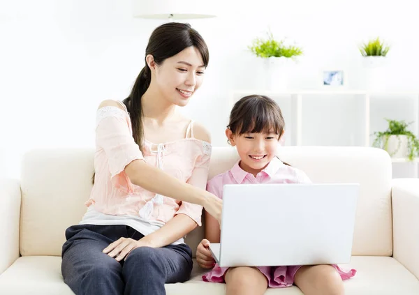Mor med dotter tittar på Laptop på soffa — Stockfoto