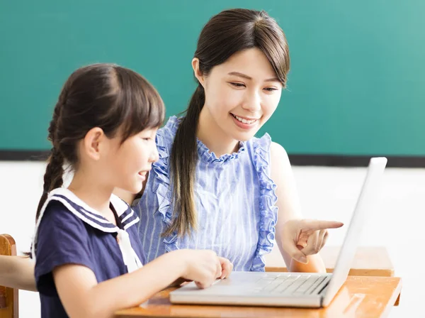 Młody nauczyciel pomaga dziecko z lekcji informatyki — Zdjęcie stockowe