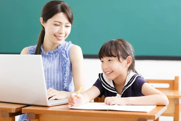 Młody nauczyciel pomaga dziecko z lekcji informatyki — Zdjęcie stockowe