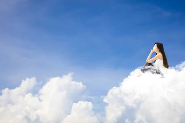 Bulut ve düşünme kavramı üzerinde oturan genç kadın — Stok fotoğraf