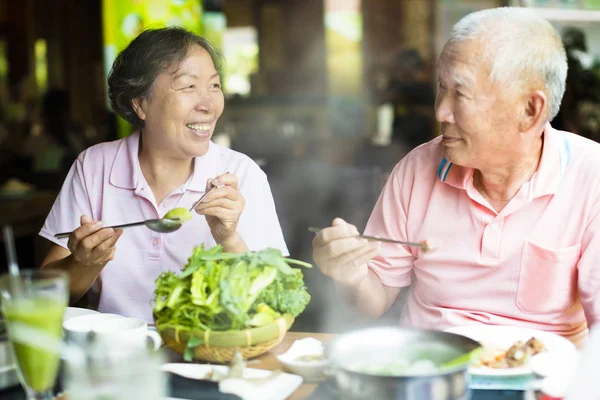 Счастливая пожилая пара Наслаждаясь горячие горшки в ресторане — стоковое фото