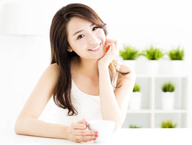 Güzel genç bayan kahve içiyor.