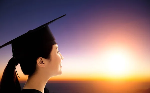 Femmina studente celebrazione laurea guardando il sorgere del sole — Foto Stock