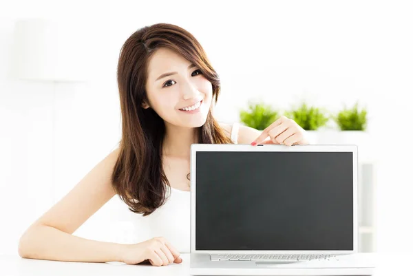 Усміхнена молода жінка показує екран ноутбука — стокове фото