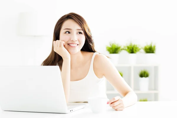Sorrindo jovem mulher com laptop na sala de estar — Fotografia de Stock