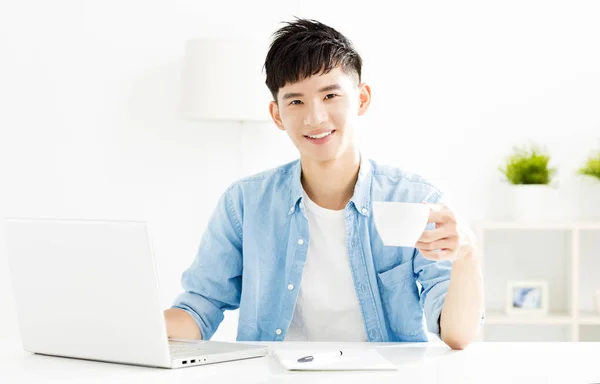 Rilassato giovane uomo che studia e beve caffè — Foto Stock