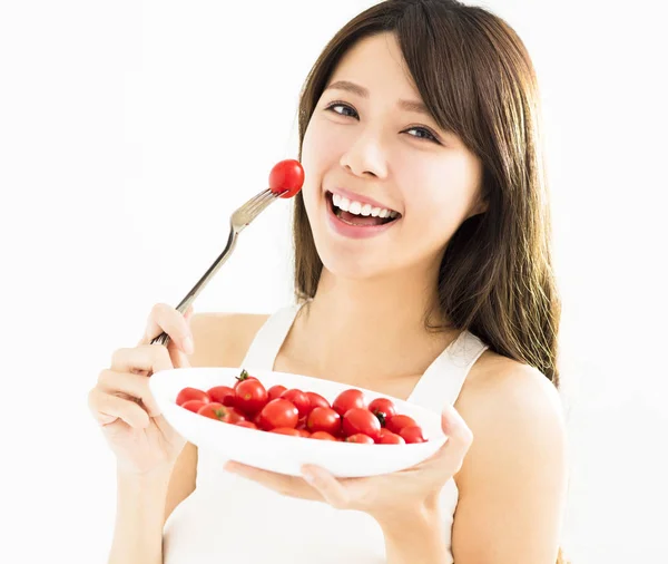 Hermosa mujer joven comiendo tomates — Foto de Stock
