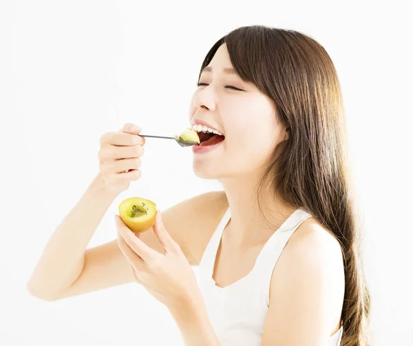 Happy young woman eating kiwi fruit — Stock Photo, Image