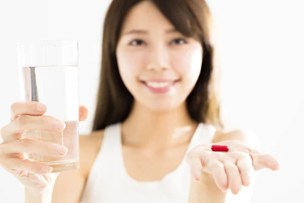 Smiling young woman showing pill in hand — Stock Photo, Image