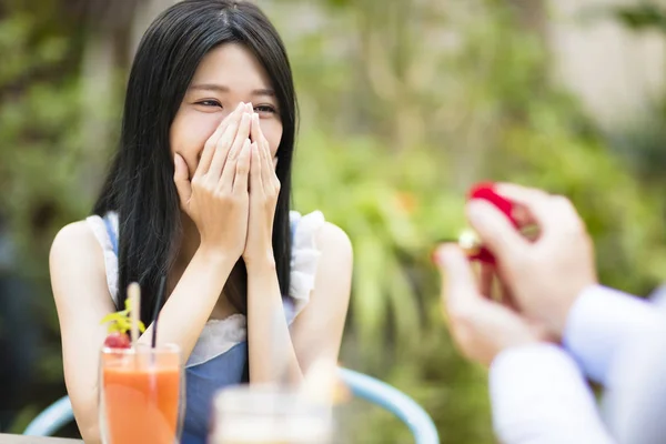 Man proposing to girlfriend offering engagement ring in restaurant — Stock Photo, Image