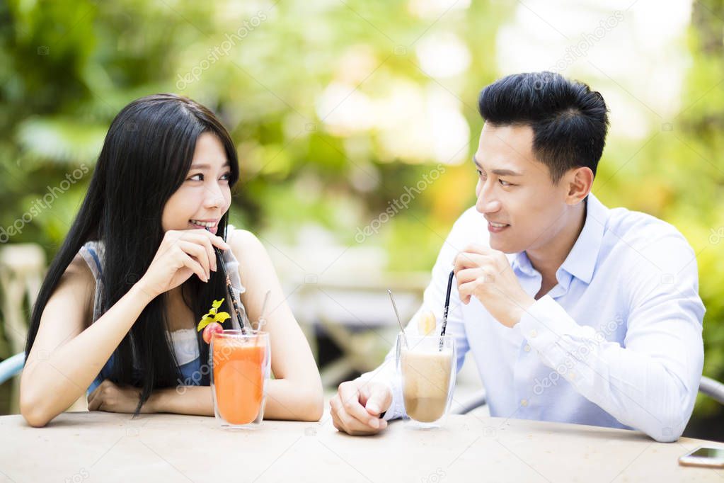 Happy young couple in restaurant enjoying drink